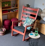 Einblick in einen Beratungsraum mit einem roten Schaukelstuhl